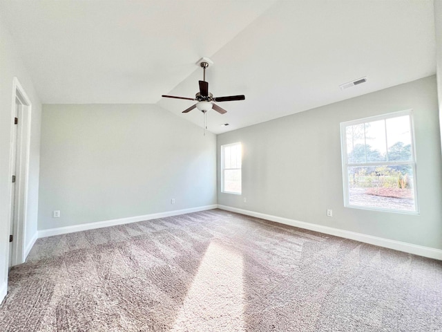 unfurnished room featuring a wealth of natural light, lofted ceiling, carpet flooring, and ceiling fan