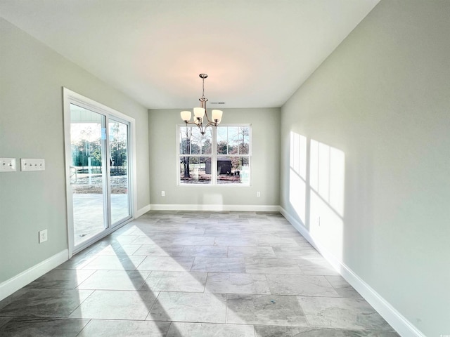 unfurnished dining area featuring an inviting chandelier