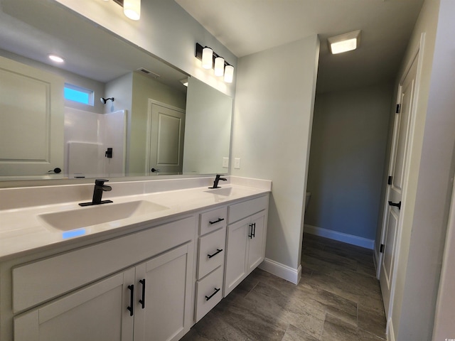 bathroom with vanity, hardwood / wood-style flooring, and walk in shower