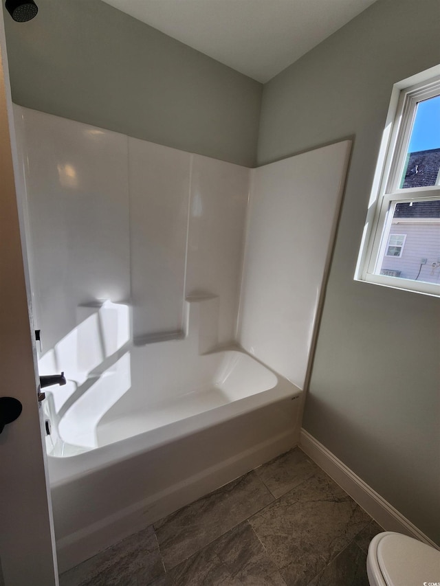 bathroom with bathtub / shower combination and toilet