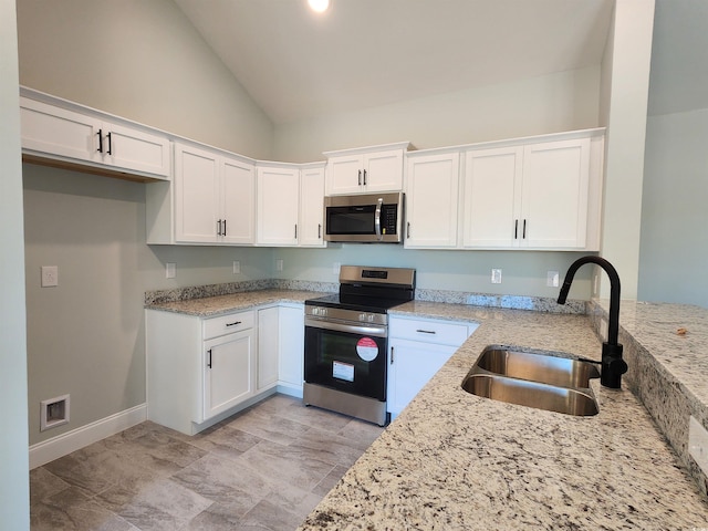 kitchen featuring appliances with stainless steel finishes, sink, white cabinetry, light stone counters, and high vaulted ceiling