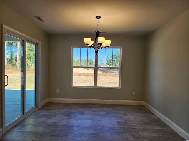 unfurnished dining area featuring a chandelier