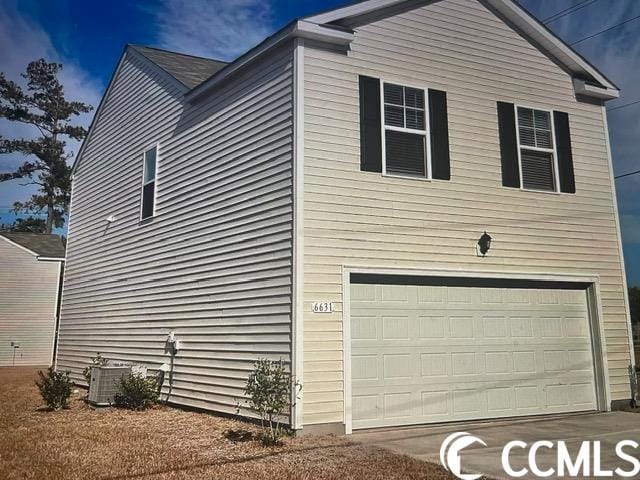 view of home's exterior with central AC and a garage