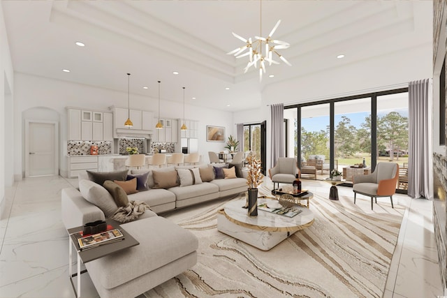 living room featuring an inviting chandelier and a raised ceiling