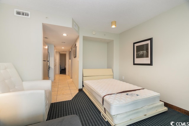 bedroom with light tile flooring and stainless steel fridge