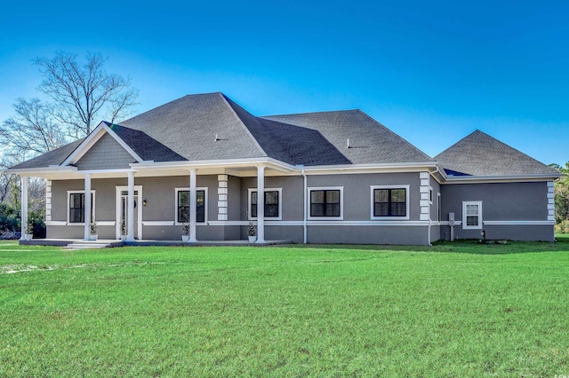 rear view of property with covered porch and a lawn