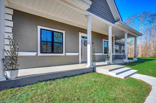 property entrance featuring a yard and a porch