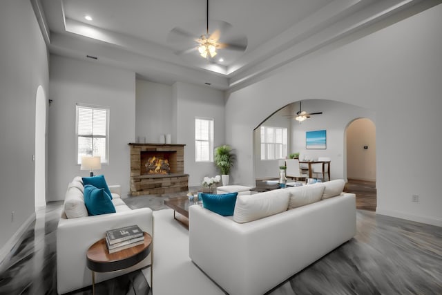 living room featuring a healthy amount of sunlight, hardwood / wood-style floors, ceiling fan, and a fireplace