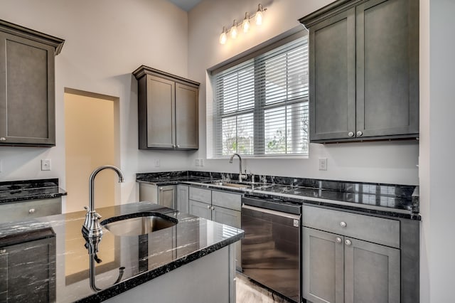 kitchen with dark stone counters, sink, and light wood-type flooring