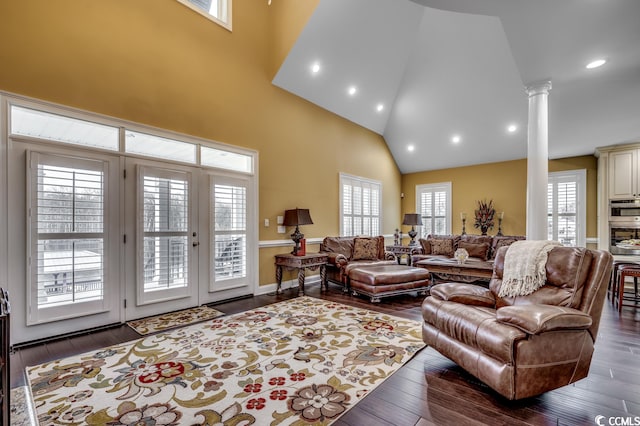 living room with decorative columns, high vaulted ceiling, and dark hardwood / wood-style floors