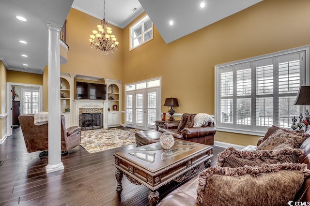 living room with crown molding, dark hardwood / wood-style floors, a notable chandelier, and a wealth of natural light