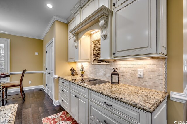 kitchen with black electric stovetop, dark wood-type flooring, ornamental molding, and tasteful backsplash