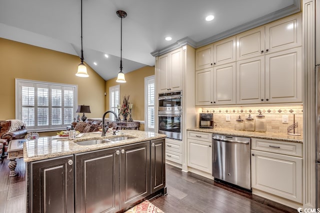 kitchen with decorative light fixtures, dark hardwood / wood-style floors, sink, stainless steel appliances, and light stone counters