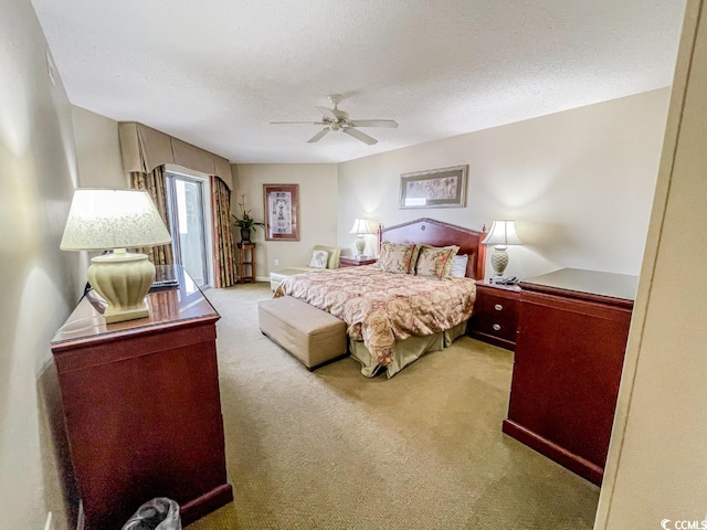 bedroom with ceiling fan, carpet flooring, and a textured ceiling