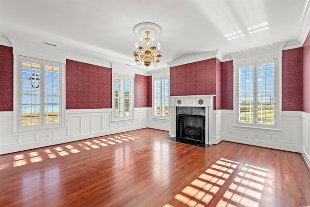 101 Greenwich Dr, Georgetown, SC 29440 - unfurnished living room featuring plenty of natural light, a chandelier, wainscoting, wood finished floors, and a premium fireplace
