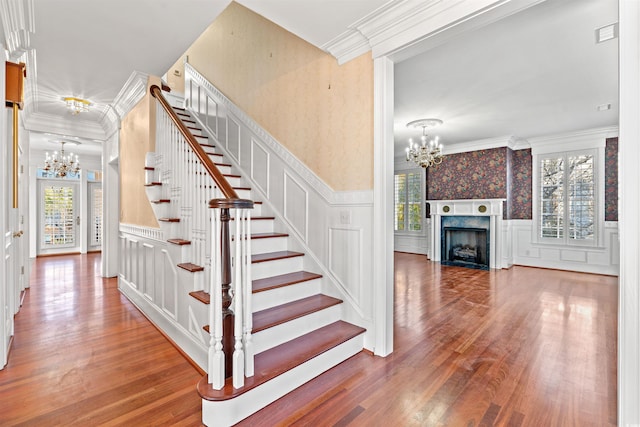 101 Greenwich Dr, Georgetown, SC 29440 - staircase featuring a chandelier, a decorative wall, wood finished floors, plenty of natural light, and ornamental molding