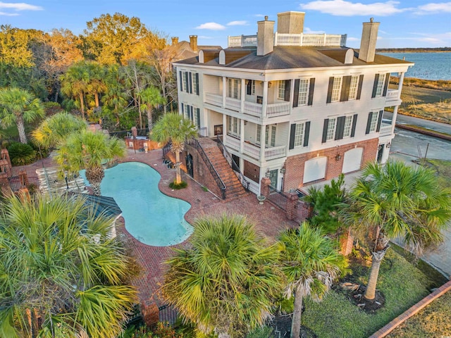 view of swimming pool featuring a patio area and a water view