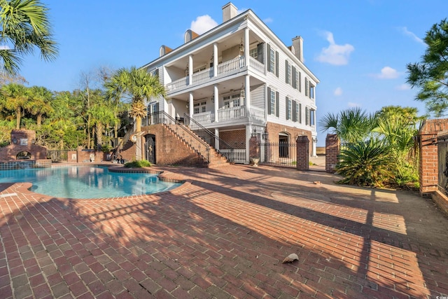 view of pool with a fireplace and a patio