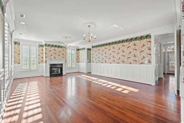 101 Greenwich Dr, Georgetown, SC 29440 - unfurnished living room with a chandelier, crown molding, wainscoting, wallpapered walls, and wood finished floors