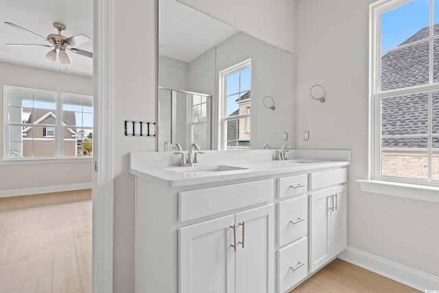 bathroom featuring ceiling fan, vanity, a shower with shower door, and hardwood / wood-style floors