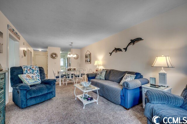 living room featuring light colored carpet, a notable chandelier, and a textured ceiling