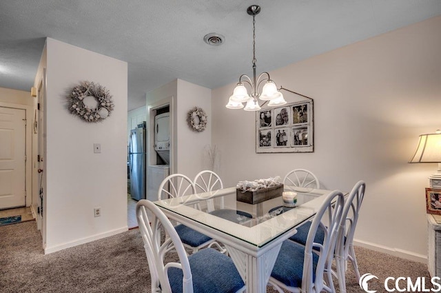 carpeted dining space with an inviting chandelier and a textured ceiling