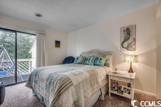 carpeted bedroom featuring a textured ceiling and access to exterior