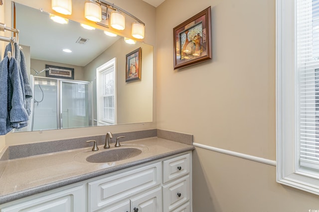 bathroom with vanity and a shower with shower door