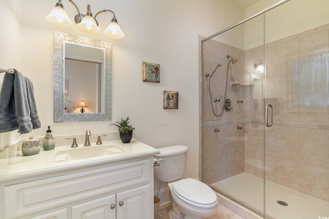 bathroom featuring vanity, a shower with shower door, and toilet