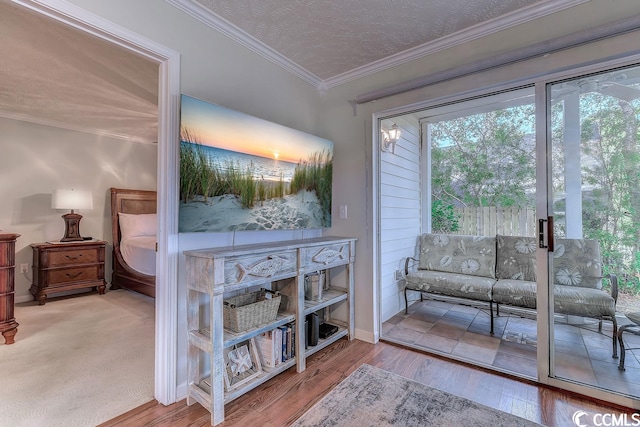 interior space with a textured ceiling, crown molding, and light colored carpet