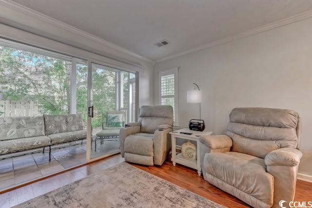 sitting room featuring crown molding and light hardwood / wood-style floors