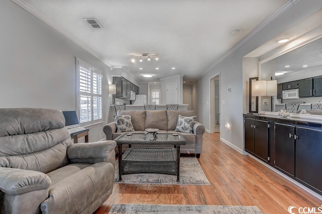 living room with ornamental molding, light hardwood / wood-style floors, and rail lighting