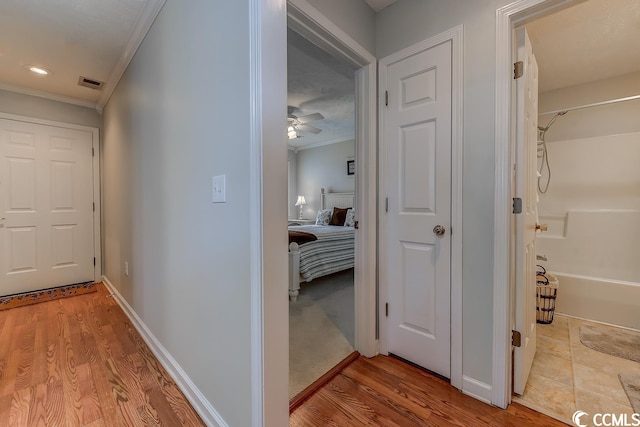 hall featuring light carpet and crown molding