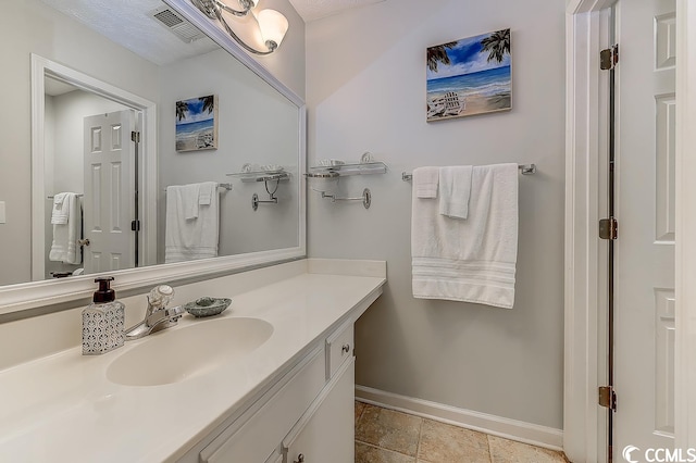 bathroom featuring a textured ceiling, tile floors, and vanity with extensive cabinet space