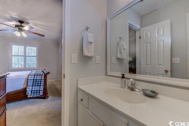 bathroom with ornamental molding, ceiling fan, and vanity