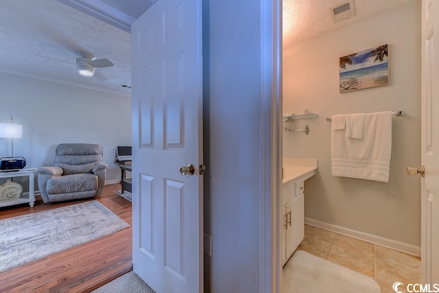 bathroom with ceiling fan, tile flooring, ornamental molding, and vanity