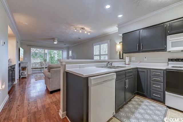 kitchen featuring kitchen peninsula, white appliances, ceiling fan, sink, and crown molding