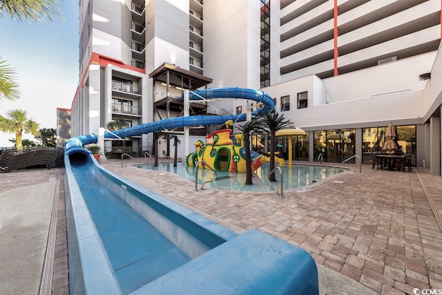 view of swimming pool featuring a patio and a water slide