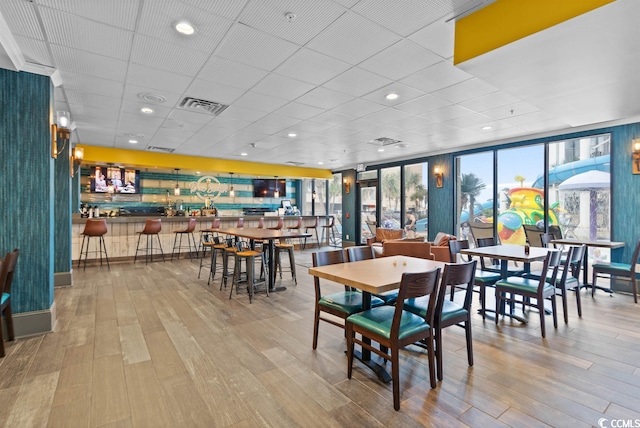 dining space with light hardwood / wood-style floors and indoor bar