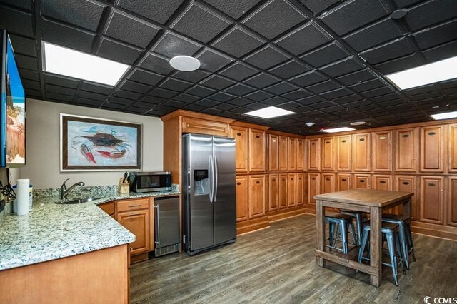 603 S Ocean Blvd Unit 1115, North Myrtle Beach, SC 29582 - kitchen featuring appliances with stainless steel finishes, a sink, dark wood-style floors, and light stone countertops