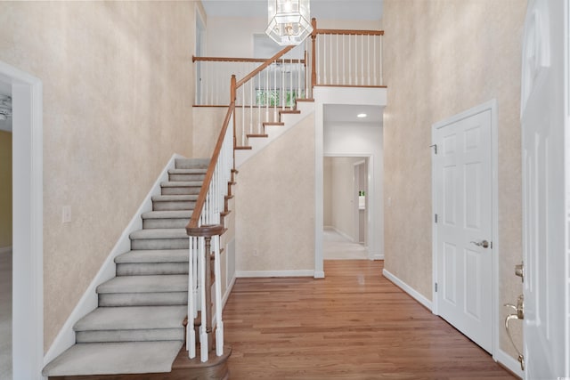 entrance foyer with a towering ceiling and hardwood / wood-style floors