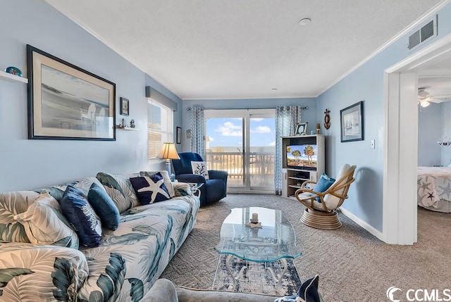 carpeted living room featuring ceiling fan and ornamental molding