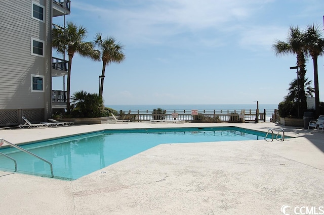 view of pool featuring a water view and a patio area