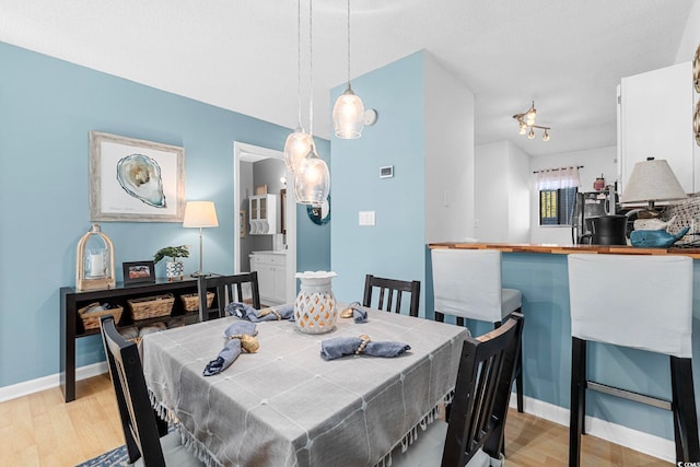 dining area featuring light hardwood / wood-style flooring and a textured ceiling