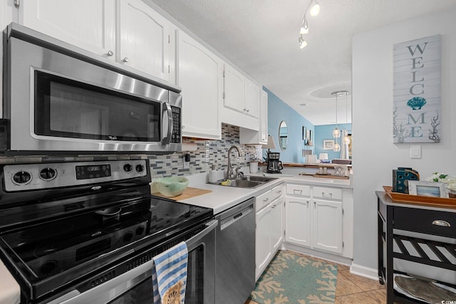 kitchen with backsplash, sink, stainless steel appliances, white cabinets, and a textured ceiling