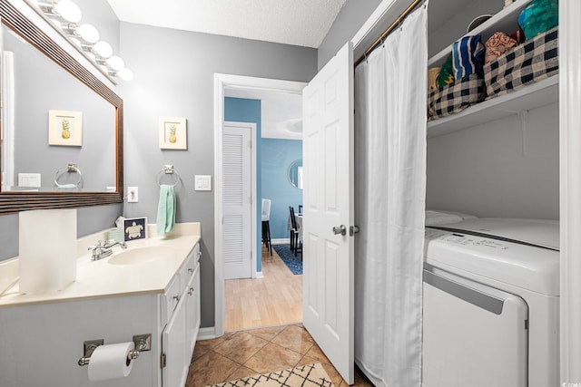 bathroom with a textured ceiling, tile floors, and large vanity