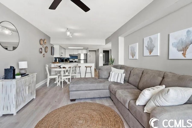 living room with ceiling fan and light hardwood / wood-style flooring