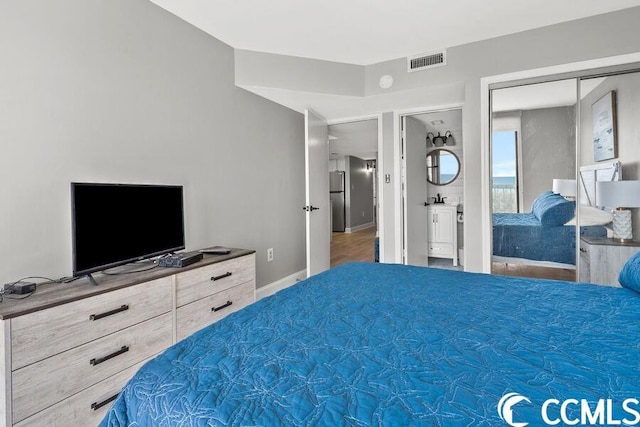 bedroom with stainless steel refrigerator and a closet