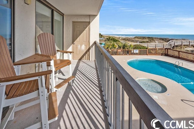 balcony with a water view and a community pool