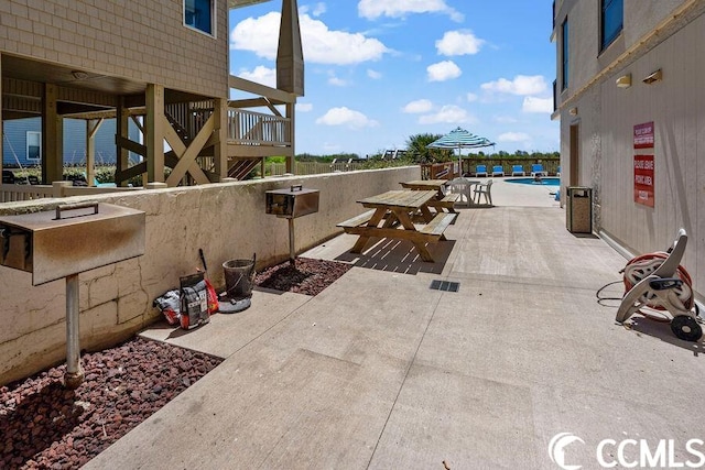 view of patio / terrace with an outdoor kitchen and a community pool